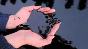 رجل يلتقط النفط في حقل أيرانكول النفطي في منطقة أتيراو، كازاخستان